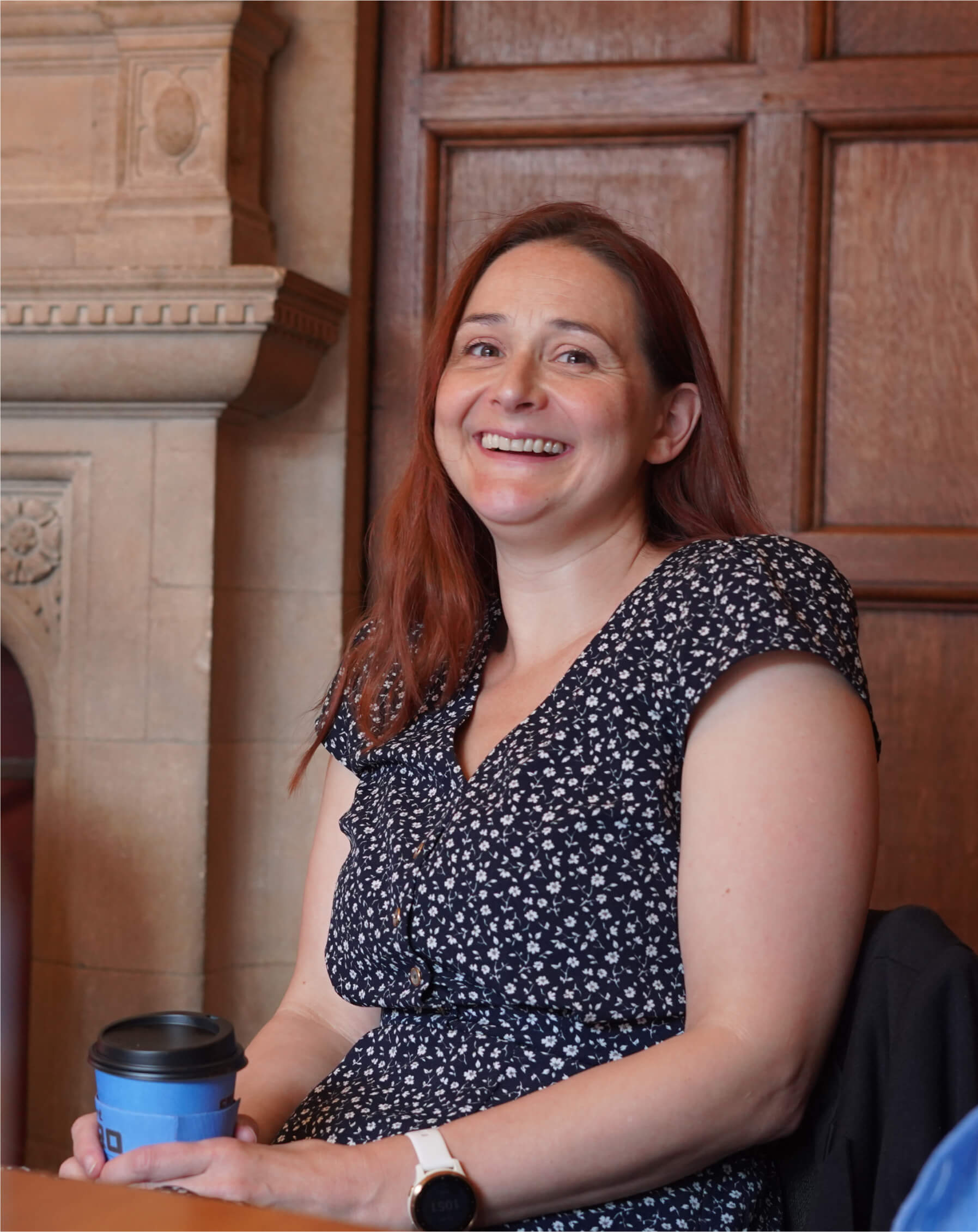 Employee laughing whilst holding coffee